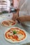 Preparing classic pizza Margherita in traditional pizzeria in Naples