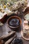 Preparing cosmetic black mud mask in ceramic bowl on vintage wooden background. Front view of facial clay emulsion on table with