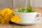 Preparing dandelion tea by pouring hot water over fresh dandelion leaves