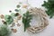 Preparing decoration for Christmas and Advent holidays, wreath from bleached wood, fir branches, gingerbread cookies, ornaments