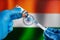Preparing dose of vaccine in syringe for infections prevention in front of the Indian flag