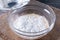 Preparing a dough/batter for crepes or pancakes with wheat flour in glass bowl, milk, eggs and oil