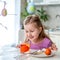 Preparing for Easter. A cute little girl sits at a table and paints eggs