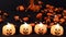 Preparing for Halloween. Orange candy slowly pours on the black background, pumpkin lanterns glow.