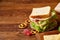 Preparing ham sandwiches for scool lunchbox on wooden background, close up.