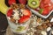 Preparing healthy breakfast for kids. Yogurt with oatmeal, fruit, nuts and chocolate. Oatmeal for breakfast. Preparing diet meals.