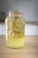 Preparing homemade elderflower syrup in a glass jar. Vertical shot