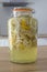 Preparing homemade elderflower syrup in a glass jar. Vertical shot