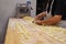 Preparing Italian Stuffed Tortelli on a Long Wooden Table