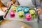 Preparing muffins for baking. Dough divided into silicone colourful cups lying on metal baking tray. Close-up of women