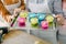 Preparing muffins for baking. Dough divided into silicone colourful cups lying on metal baking tray. Close-up of women