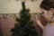 Preparing for the new year. Teen girl washes an artificial Christmas tree in the bathroom. Christmas tree in the shower