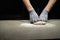 Preparing pizza dough.Male baker\'s hands in rubber gloves knead dough for Italian pizza on the work table. Baking process