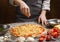 Preparing pizza. Woman adding cheese to pizza