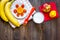 Preparing quick lunch for schoolchild. Fruits on dark wooden table background top view copyspace