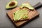 Preparing sandwiches with avocado, healthy organic food. Sliced avocado on toast.