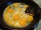 Preparing scrambled eggs on a frying pan