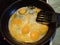 Preparing scrambled eggs on a frying pan