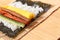 Preparing sushi on sushi mat with ingredients