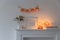 Preparing your home for Halloween. A garland of pumpkins on the wall above fake dresser panel. Frame with the inscription, orange