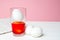 Prepearing for Easter. White eggs is coloring painting in glass with orange color. pink background. copyspace