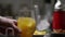 Prepearing orange juice coctail with ice. Bartender prepare coctail in modern bar. Barmen stirring and pouring. The