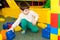 A preschool boy plays with large blocks of construction set in the playroom, a children's entertainment center, an