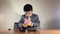 Preschool boy in a suit trying to get more money from an empty piggy bank. Recession and negative returns on investment