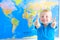 Preschool boy with world map, thumbs up