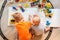 Preschool boys drawing on floor on paper, playing with educational toys - blocks, train, railroad, vehicles at home or daycare.