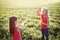 Preschool Caucasian girls blowing soap bubbles in park on summer day. Kids having fun outdoors. Authentic happy childhood magic