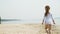 preschool girl with dances a  gymnastic ribbon on a sandy beach. Summer, dawn