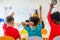 Preschool kid raise arm up to answer teacher question on whiteboard in classroom,Kindergarten education concept