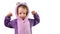 preschool little girl shows strong strength tensing muscles in purple pajamas