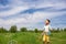 Preschooler boy blows big soap bubbles in a field on a bright sunny day