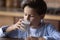 Preschooler boy drinking milk from glass during breakfast in kitchen