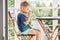 Preschooler boy drinks mug of warm milk in early morning