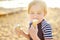 Preschooler boy eating ice cream on hot summer day on beach during family holiday.Gelato is loved delicacy for kids. Sweets are