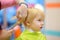 Preschooler boy getting haircut. Children hairdresser with professional tools - comb and scissors.