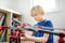 Preschooler boy playing with big construction building crane toy at home. Kids leisure activity. Entertainment for children