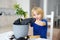 Preschooler boy watering a houseplant calamondin after transplanting into new big flowerpot. Fortunella. Home gardening