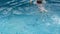 Preschooler child swims and dives in an empty pool