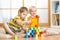 Preschooler children playing with colorful toy blocks. Kid playing with educational wooden toys at kindergarten or day care center