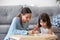 Preschooler girl entertain drawing picture with young mom