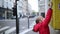 preschooler girl putting letter in yellow post box on a street of Paris, France