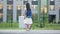 Preschooler girl with schoolbag walks past school building