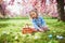 Preschooler girl wearing bunny ears playing egg hunt on Easter