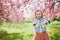 Preschooler girl wearing bunny ears playing egg hunt on Easter