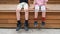 Preschooler kids boy and girl legs in sneakers on bench