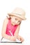 Preschooler little girl wearing a hat at the table draws